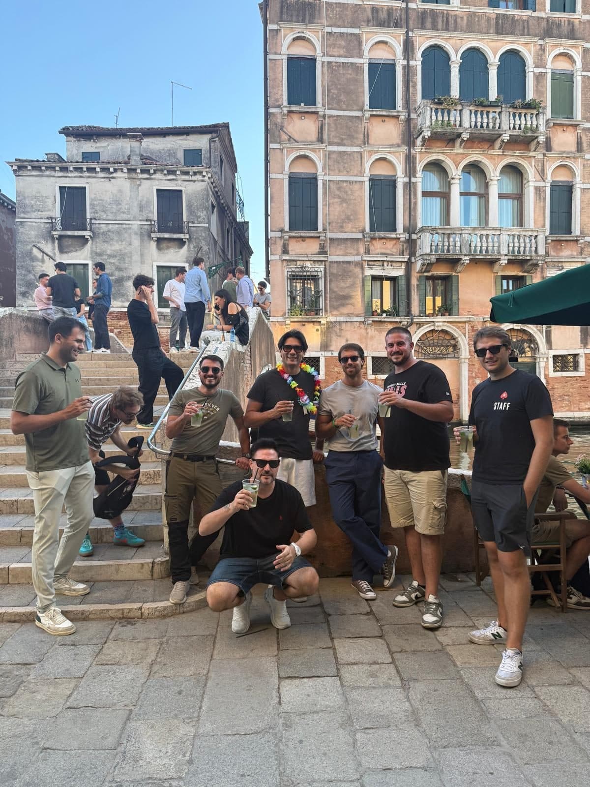 A group of friends with drinks by the bridge on the fondamenta